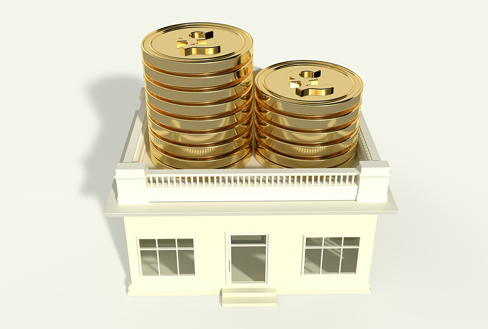 Two stacks of coins with pound signs on them, on top of a single story home