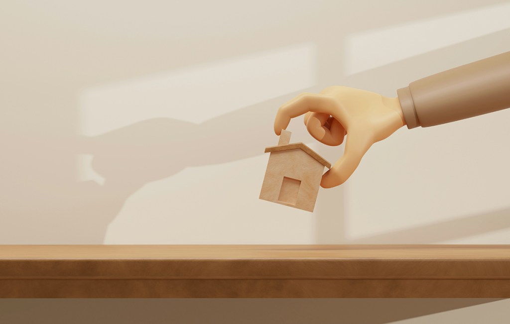 An illustration of a  hand picking up a small model of a home in a pincer grip, from a tabletop. There is a shadow of the arm on the wall behind.