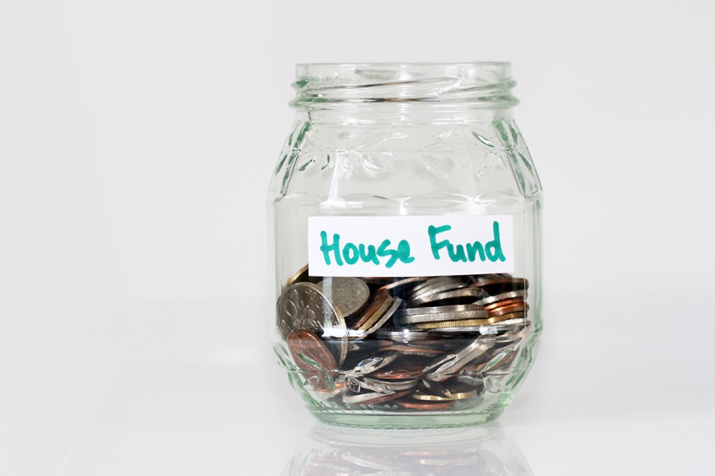 Clear jar with a label saying 'house fund', with coins inside